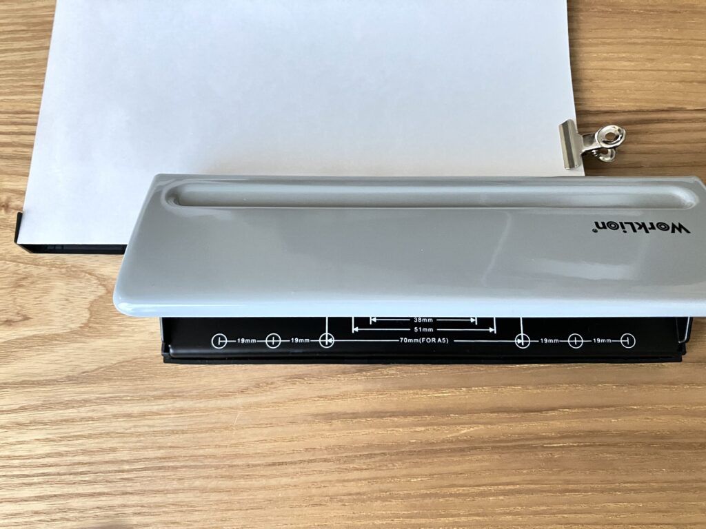 A5用紙を6穴パンチのガイドに合わせて、そのまま打ち抜く様子